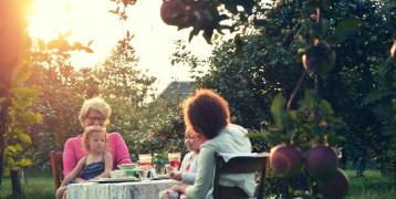 two women and two children sitting in a garden