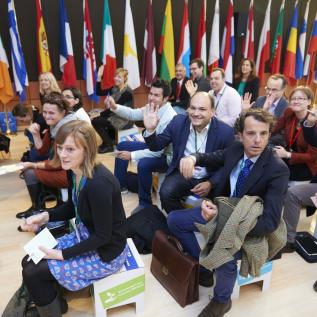 People sitting and raising hands