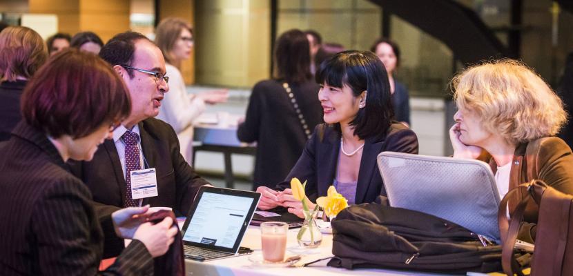 People speaking around a table at an event