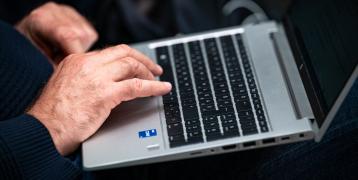 Man sitting down and using laptop.